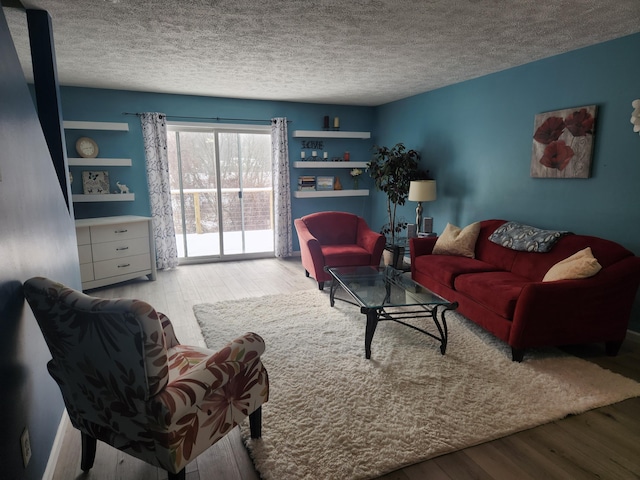 living area with light wood-style flooring and a textured ceiling