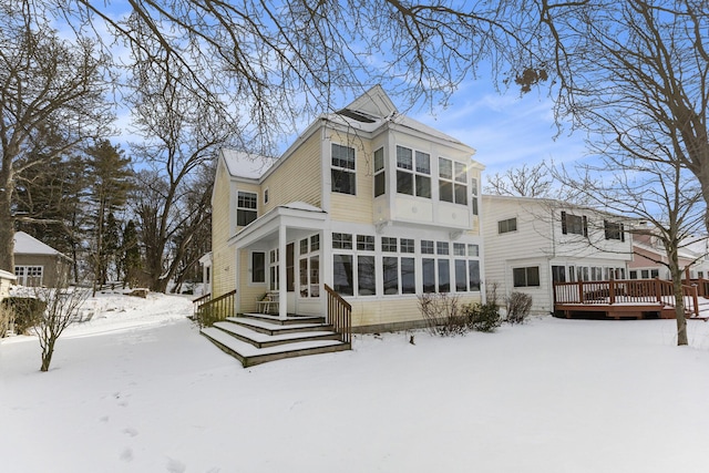 snow covered property with a sunroom