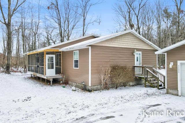 view of snowy exterior featuring a sunroom