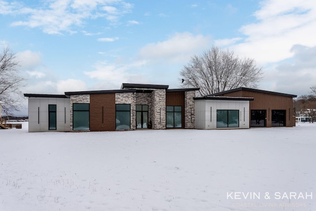 snow covered house with stone siding