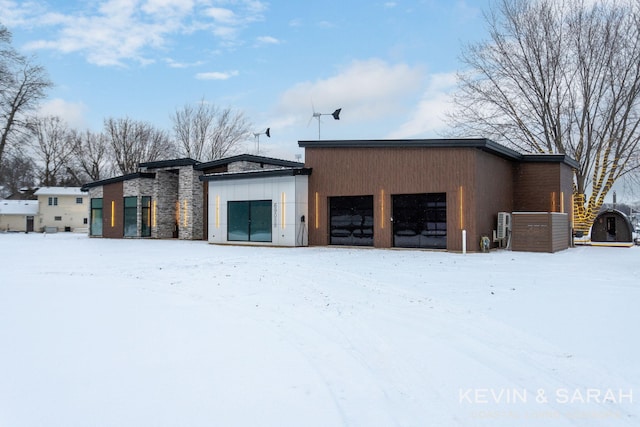 snow covered structure featuring a garage