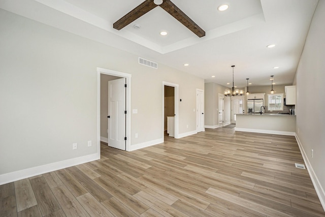 unfurnished living room with a notable chandelier, recessed lighting, visible vents, light wood-style flooring, and baseboards