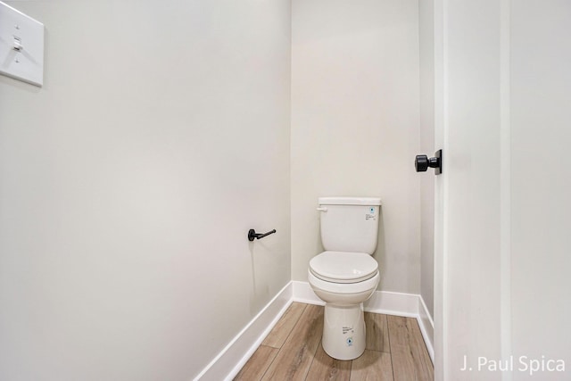 bathroom featuring baseboards, toilet, and wood finished floors