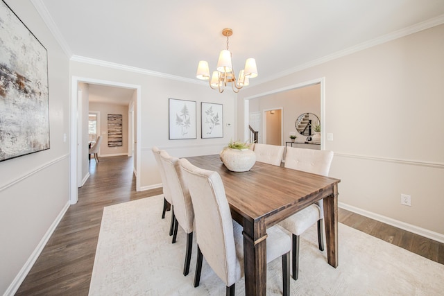 dining room with a chandelier, crown molding, baseboards, and wood finished floors