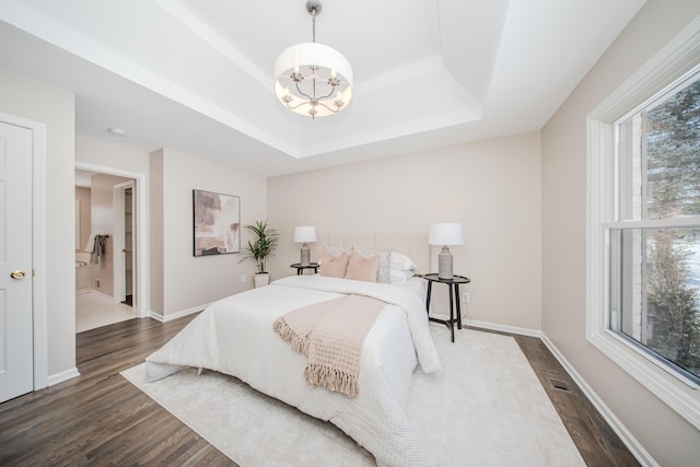 bedroom with a notable chandelier, baseboards, a raised ceiling, and dark wood-style flooring