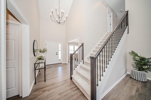 entrance foyer featuring stairs, baseboards, and wood finished floors