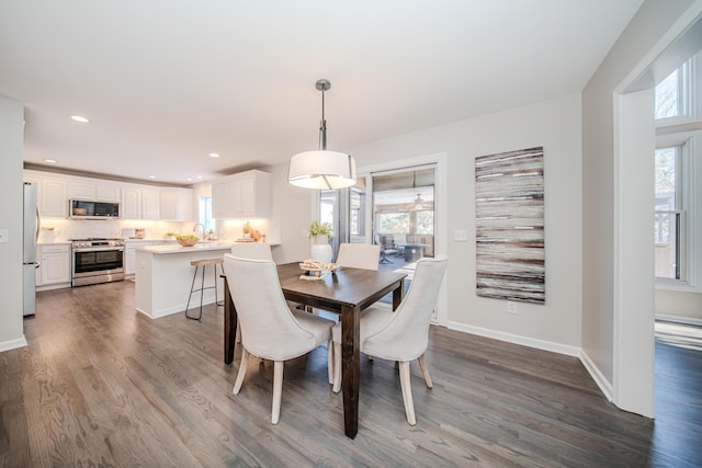 dining space with a healthy amount of sunlight, baseboards, dark wood finished floors, and recessed lighting