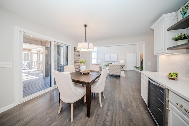 dining space featuring beverage cooler, baseboards, and dark wood-style flooring