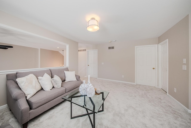 living room featuring light colored carpet, visible vents, and baseboards