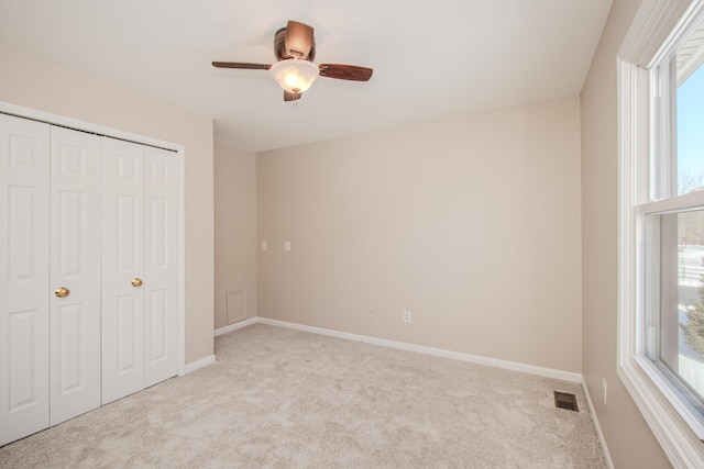 unfurnished bedroom featuring light carpet, baseboards, and visible vents