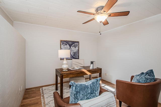 office space featuring ceiling fan, light wood-style flooring, and crown molding