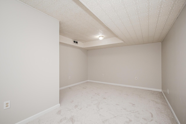 carpeted spare room with visible vents and baseboards