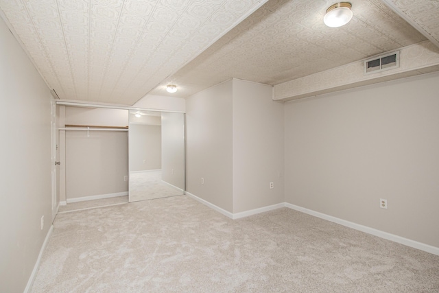 finished basement featuring light carpet, visible vents, and baseboards