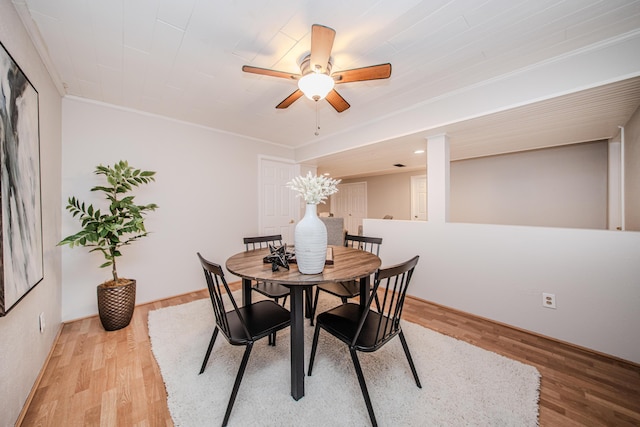 dining room with light wood-style floors, ornamental molding, and a ceiling fan