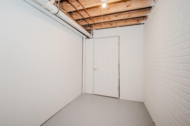 unfinished basement featuring brick wall