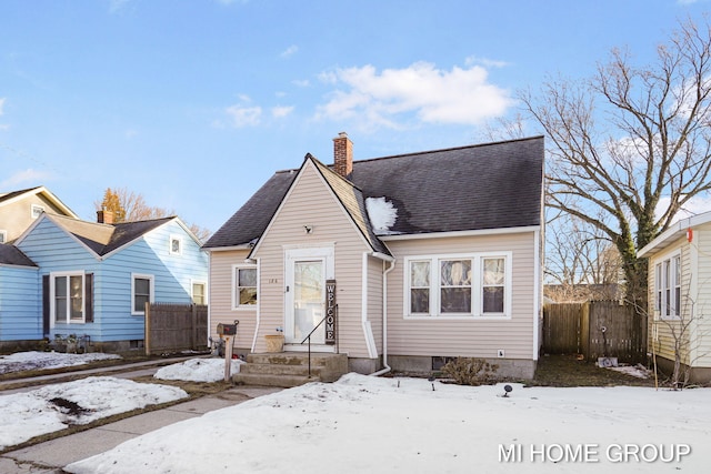 bungalow featuring entry steps, a chimney, fence, and roof with shingles