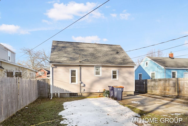 back of house featuring a fenced backyard, roof with shingles, and a patio