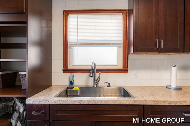 kitchen with tasteful backsplash, light countertops, and a sink