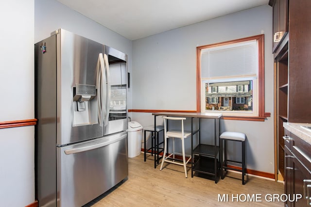 kitchen featuring dark brown cabinetry, baseboards, stainless steel fridge with ice dispenser, light countertops, and light wood-type flooring