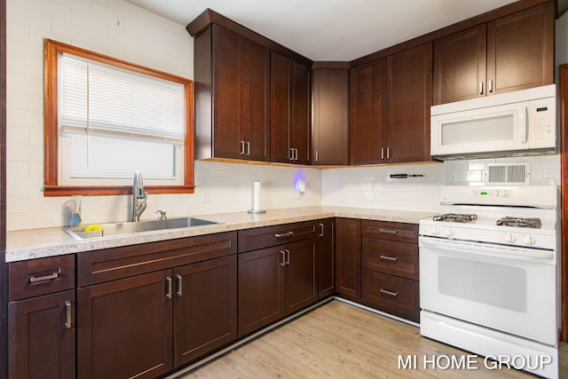 kitchen with white appliances, a sink, dark brown cabinetry, and tasteful backsplash