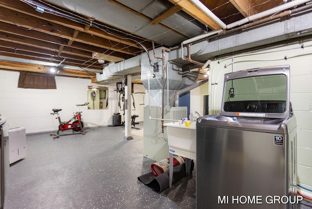 unfinished basement featuring washer / clothes dryer and concrete block wall