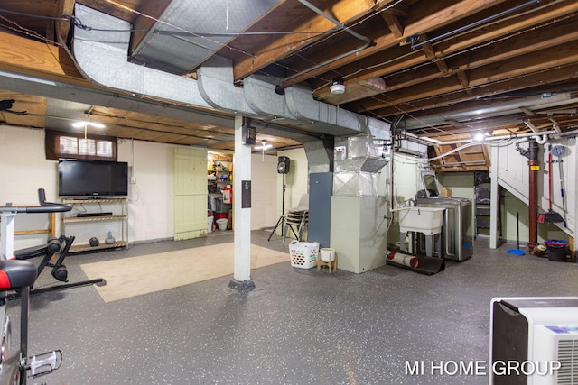 unfinished basement with heating unit, washer / dryer, a sink, and concrete block wall