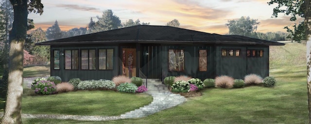 view of front of home with a standing seam roof, metal roof, and a front lawn