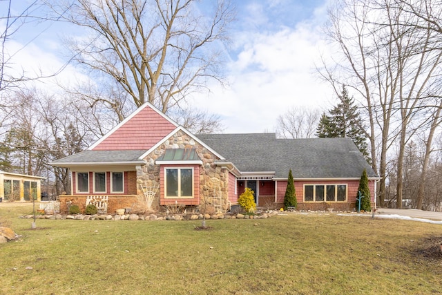 craftsman house featuring stone siding, a shingled roof, and a front yard