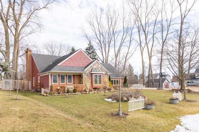 craftsman-style home featuring brick siding, a chimney, a front yard, and fence