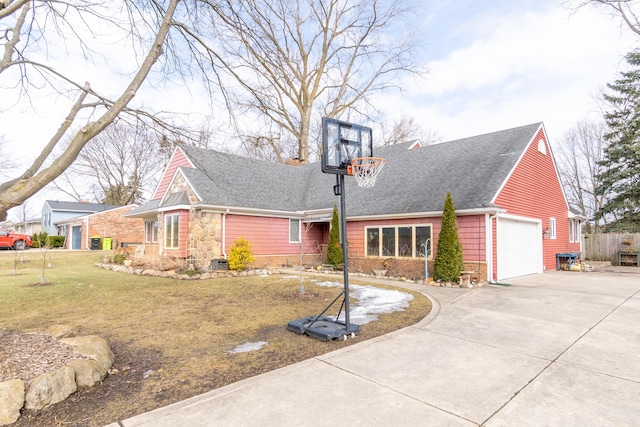 view of front facade with an attached garage, a shingled roof, fence, concrete driveway, and a front lawn