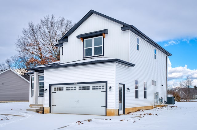 view of front of home with central AC unit and an attached garage