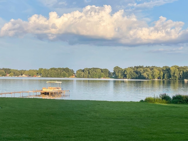 property view of water with a dock and a forest view