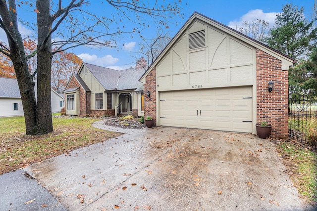 view of front of house with an attached garage, a chimney, concrete driveway, and brick siding