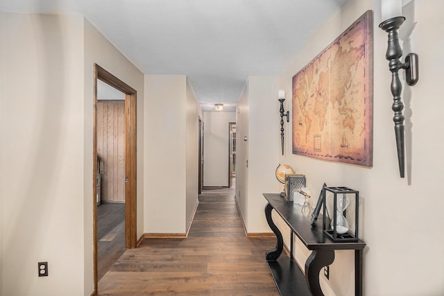 hall featuring baseboards and dark wood finished floors