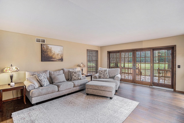 living area featuring french doors, wood finished floors, visible vents, and baseboards