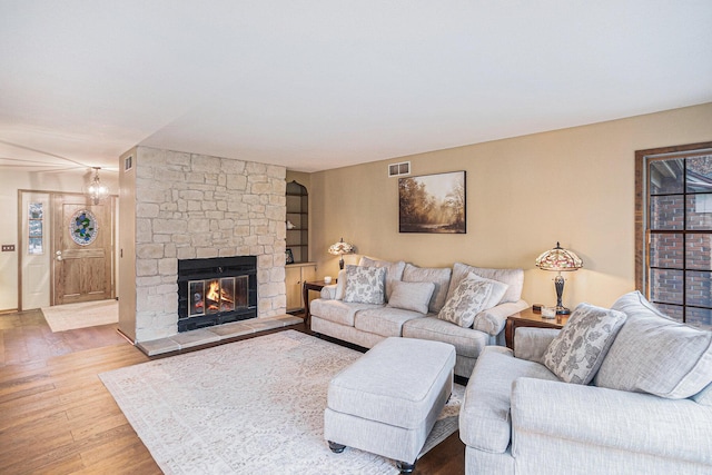 living room featuring a fireplace, wood finished floors, and visible vents