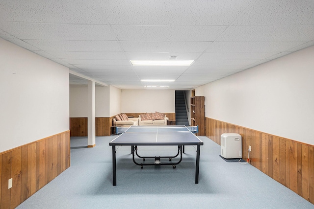 game room with carpet, wainscoting, wood walls, and a paneled ceiling