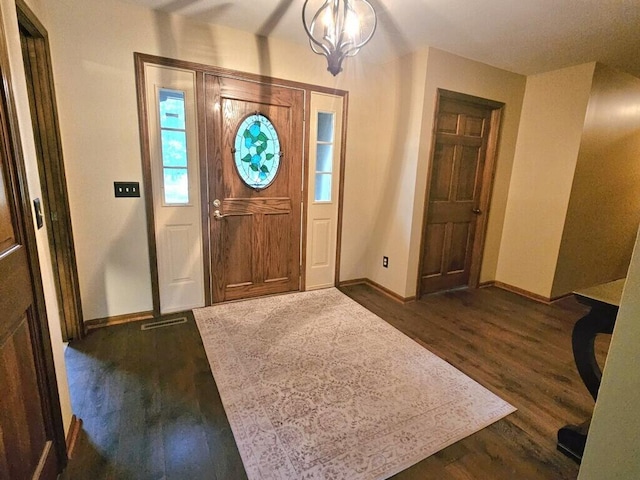 foyer featuring visible vents, baseboards, a chandelier, and dark wood-style flooring