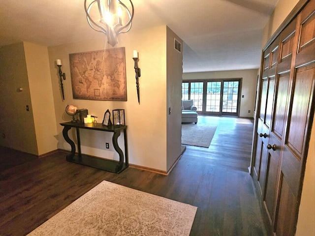 corridor with baseboards, visible vents, and dark wood finished floors