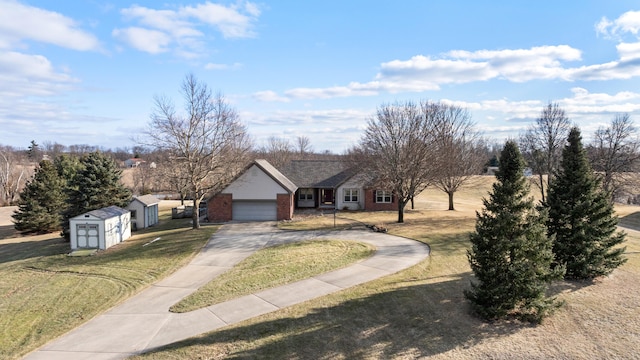 view of front of home featuring brick siding, an attached garage, driveway, and a front lawn