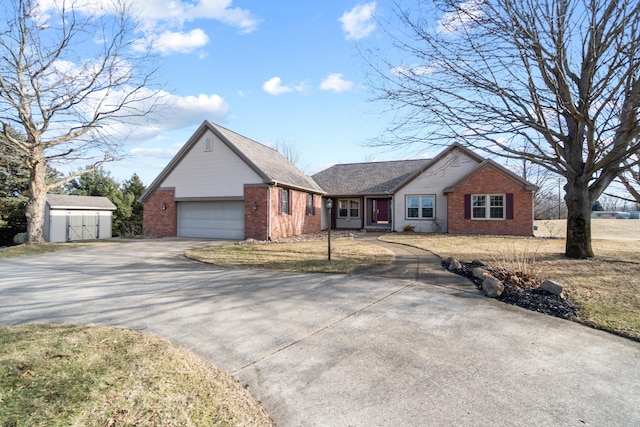 ranch-style house featuring an outbuilding, brick siding, driveway, and an attached garage