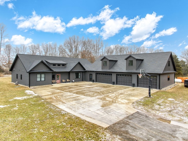 modern farmhouse featuring a garage, driveway, and a front lawn