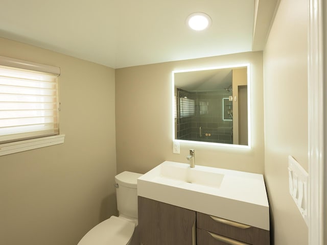 full bathroom with an enclosed shower, vanity, and toilet