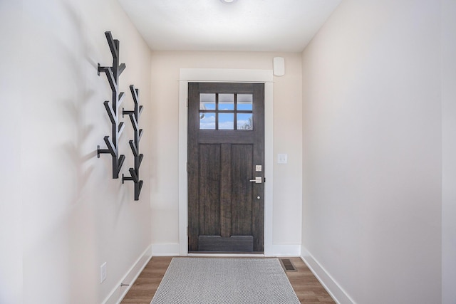 entrance foyer with baseboards and wood finished floors