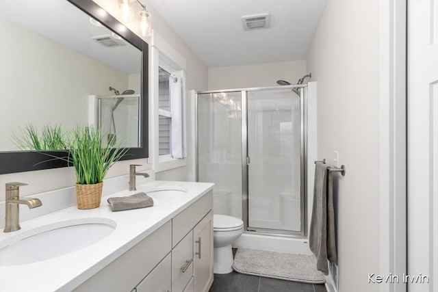 bathroom with a stall shower, visible vents, and a sink