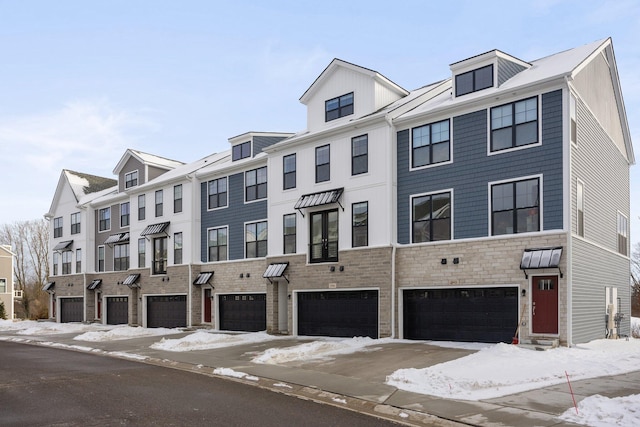 multi unit property with a garage and stone siding