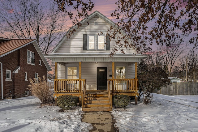 bungalow with a porch and fence