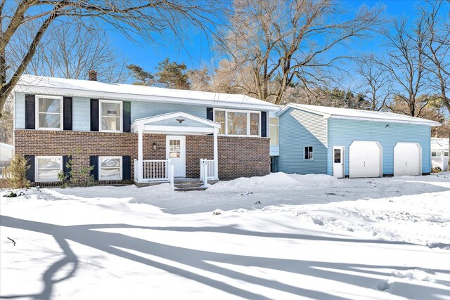 bi-level home featuring a chimney and brick siding