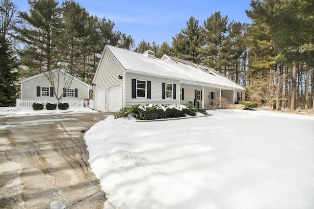 view of front of property with an attached garage, a chimney, and a porch