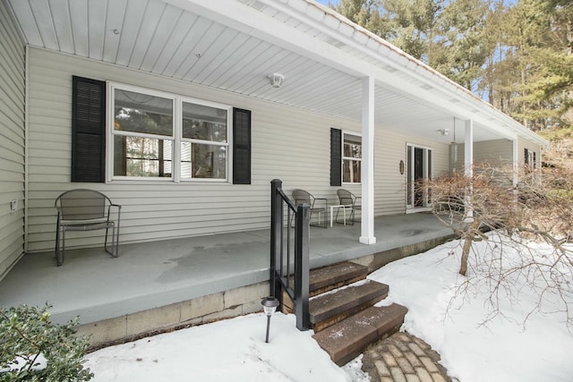 snow covered patio featuring a porch